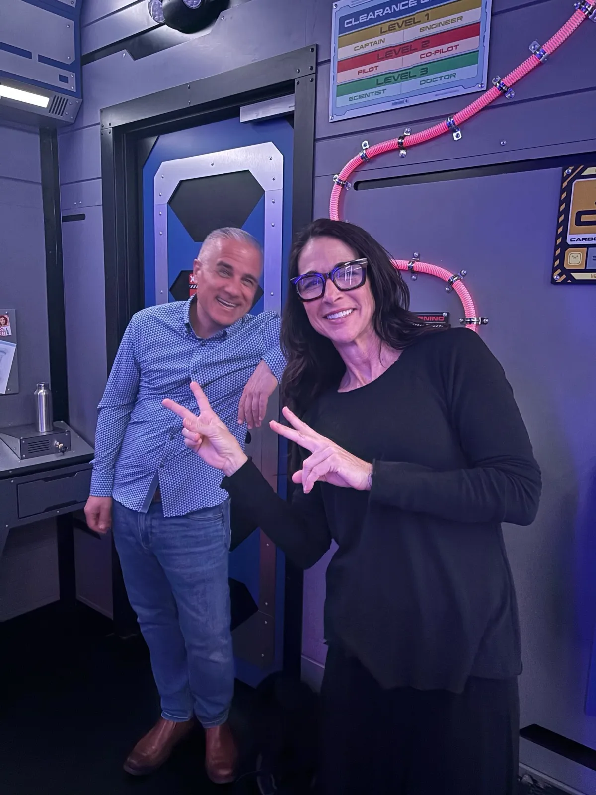 Two teammates throwing peace signs at a team outing