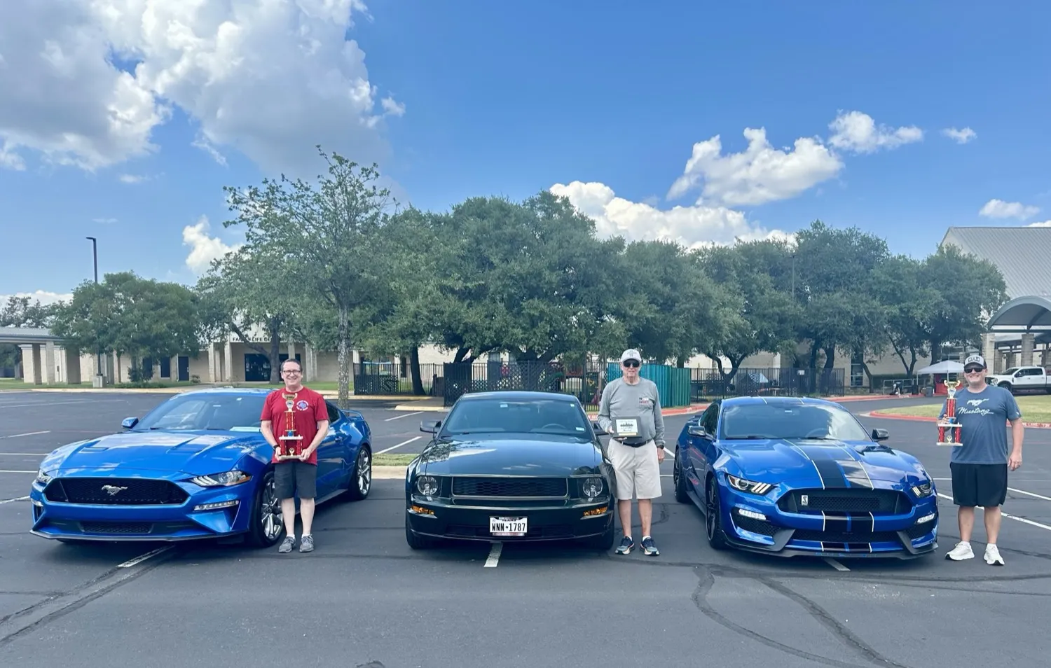 CarEdge teammates showing off their cars and trophies